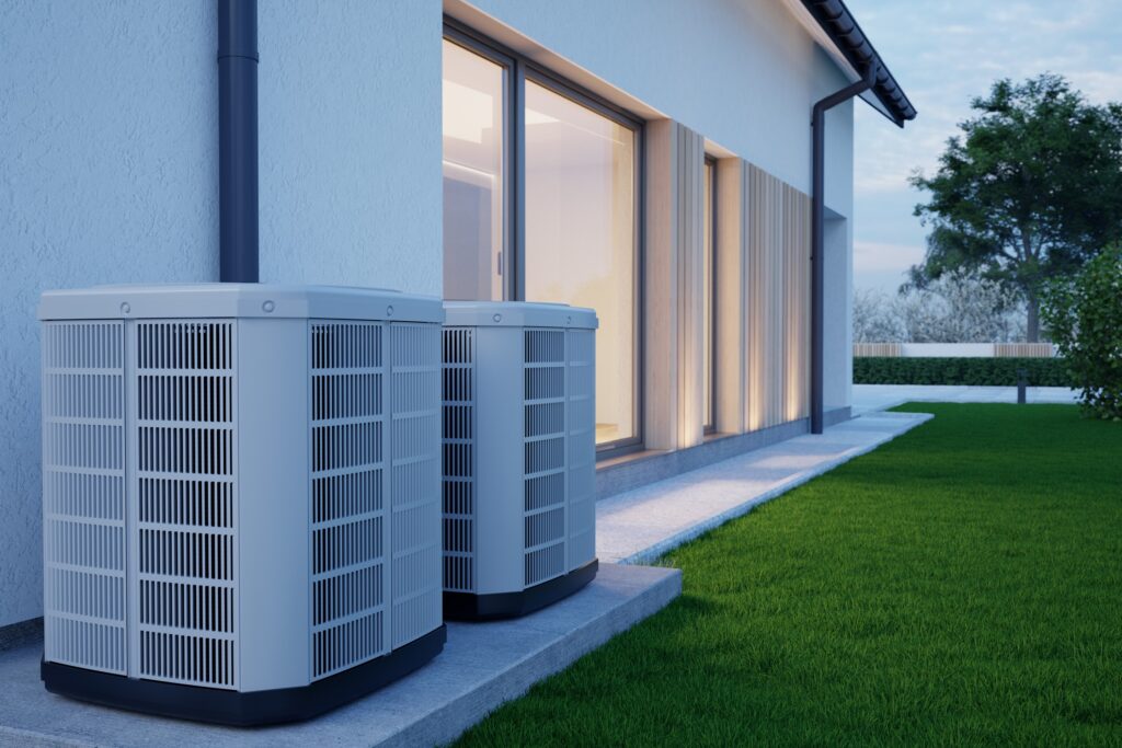 Two residential air conditioners installed outside of a home