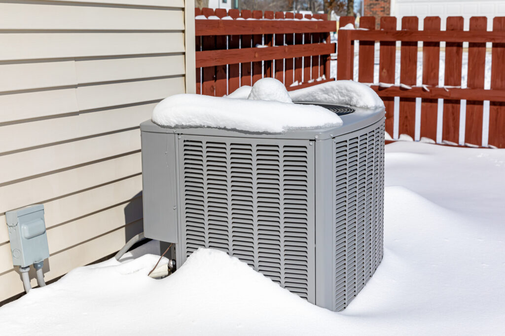 air conditioning unit covered in snow during winter.